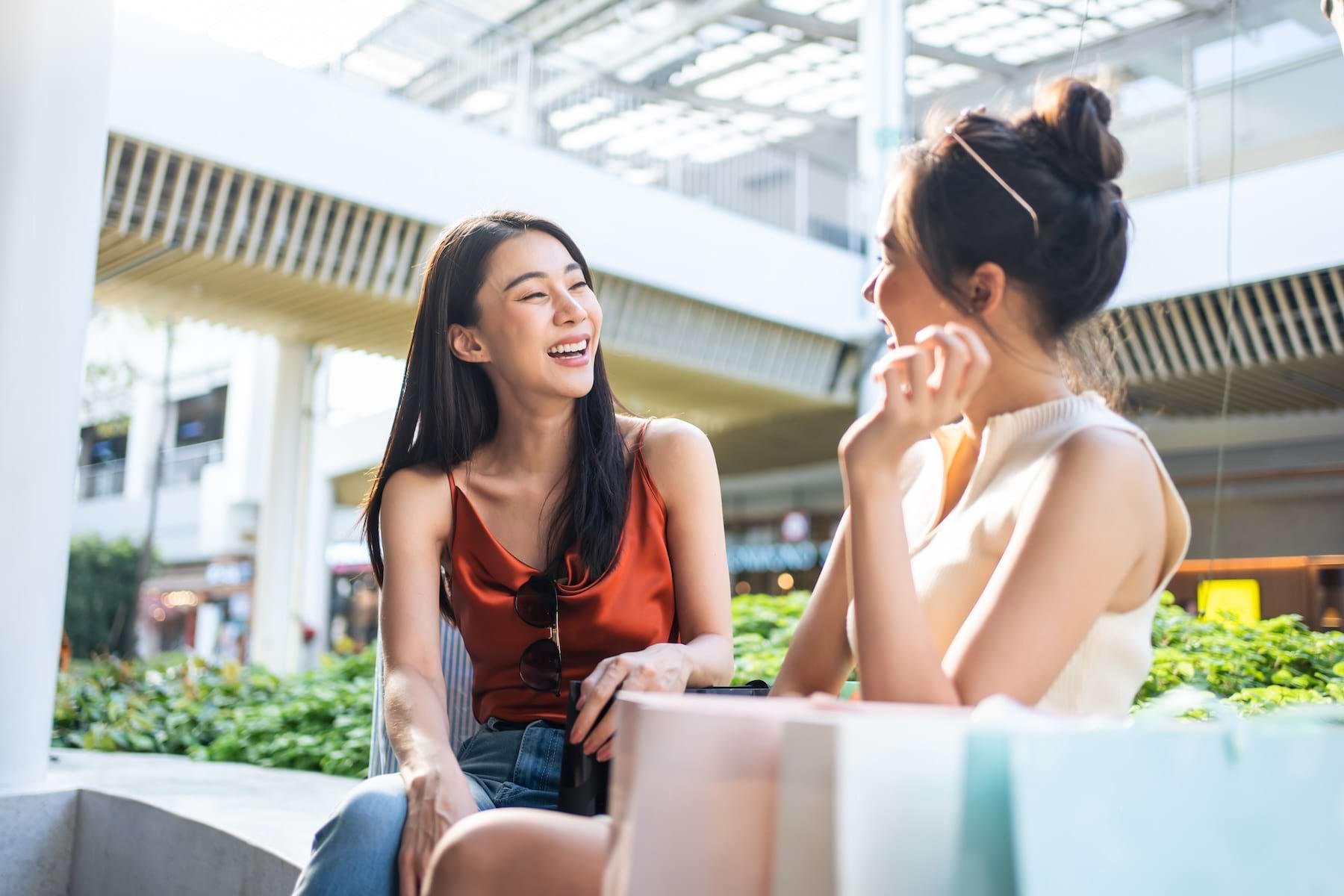 two friends laughing in a shopping center