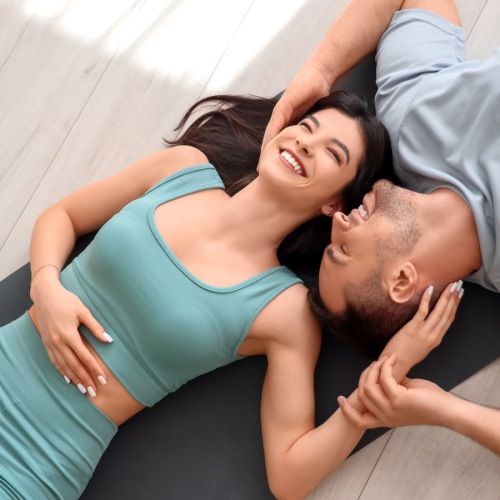Get your workout on a couple lying down in a yoga studio