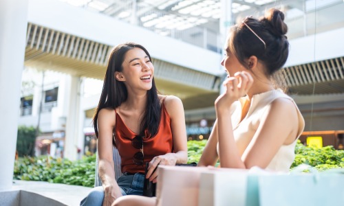 two friends laughing in a shopping center