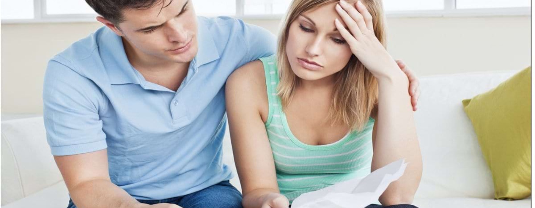 A worried couple reviewing bills and calculating rent payments while applying for an apartment in Los Angeles.